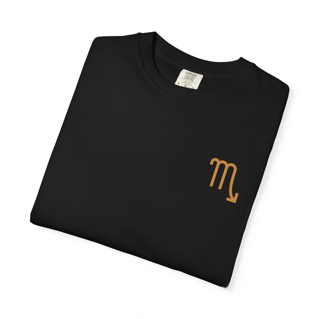 Folded black t-shirt with a gold Scorpio symbol on a white background