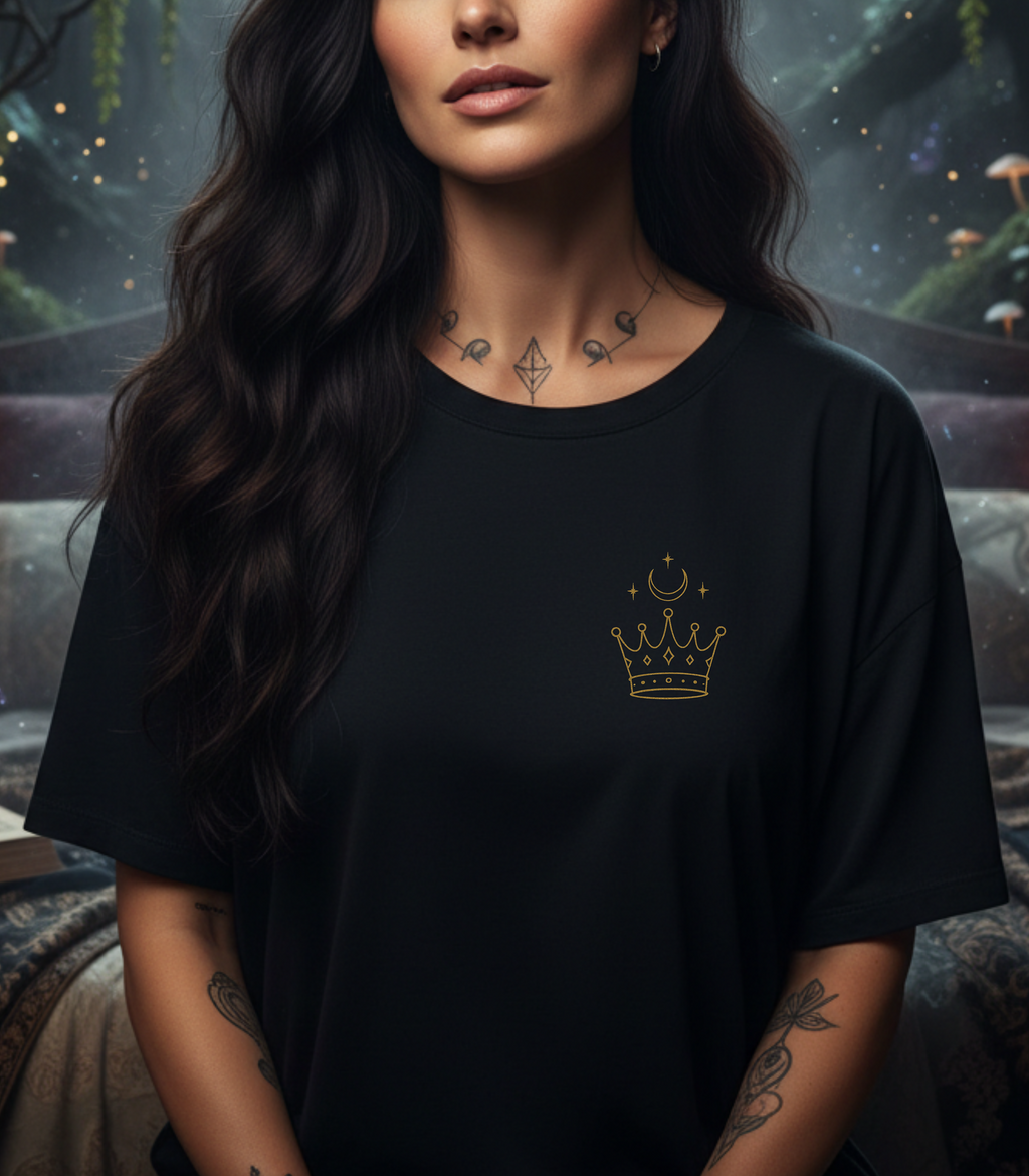 Woman wearing a black t-shirt with a gold crown design against a mystical background