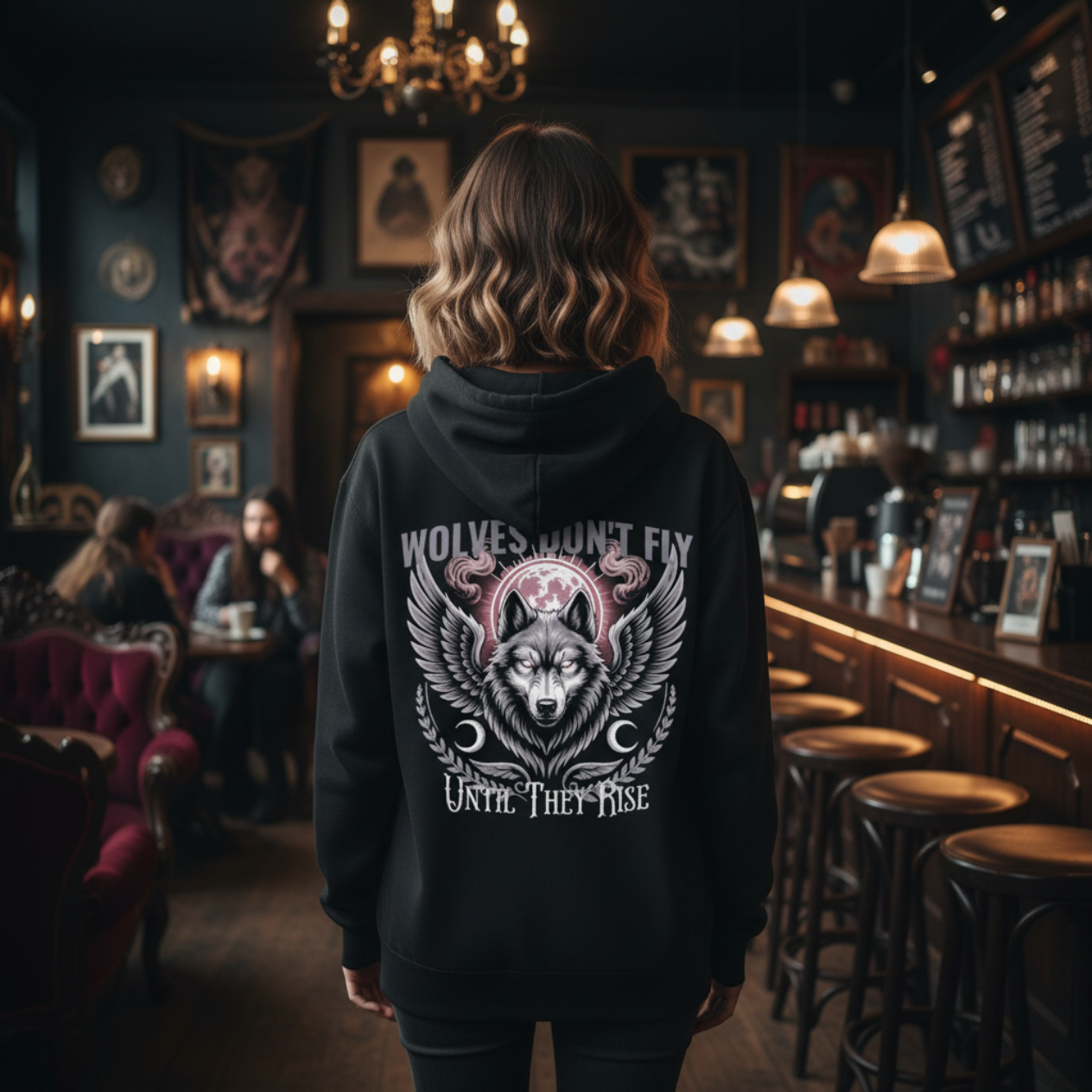 Person wearing a black hoodie with a wolf design in a bar setting