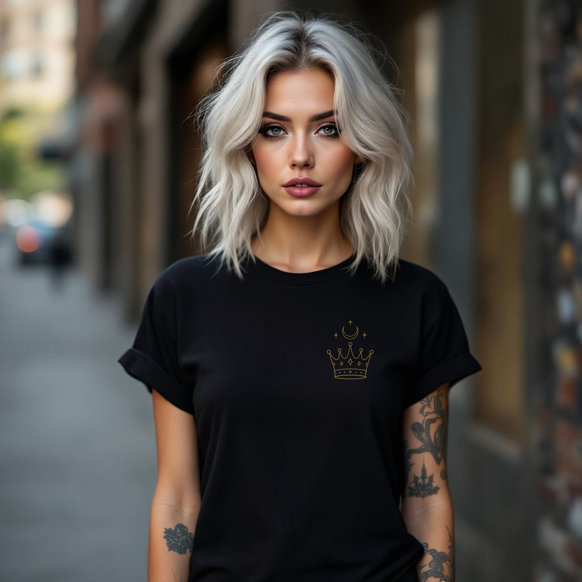 Woman wearing a black t-shirt with a crown emblem on a city street.