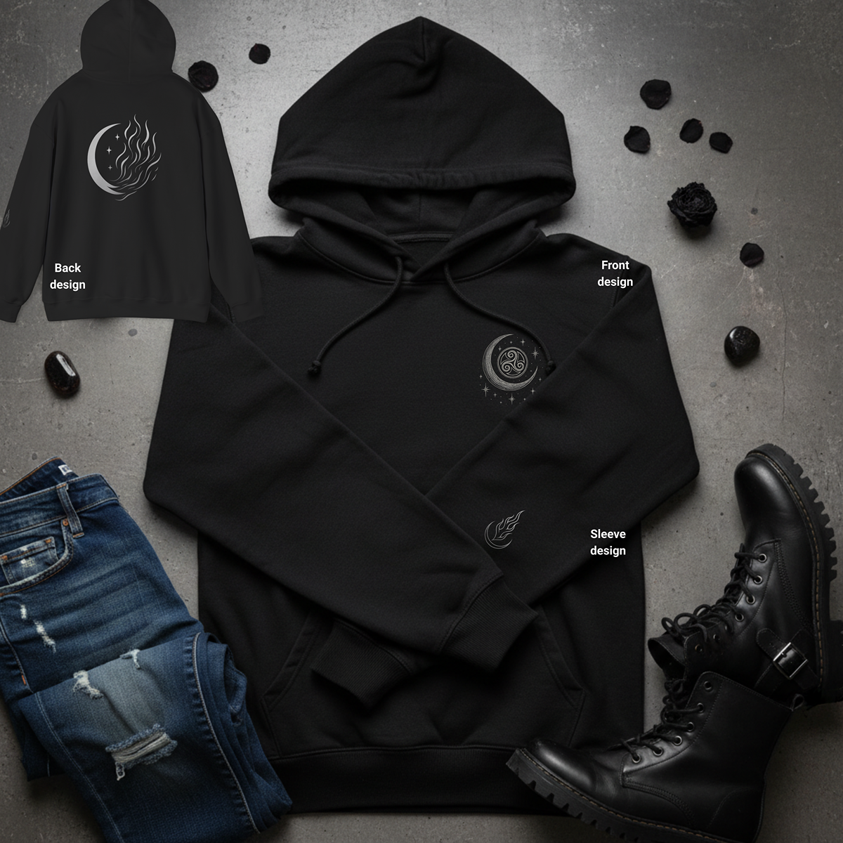 Black hoodie with designs on a gray surface with jeans and boots.