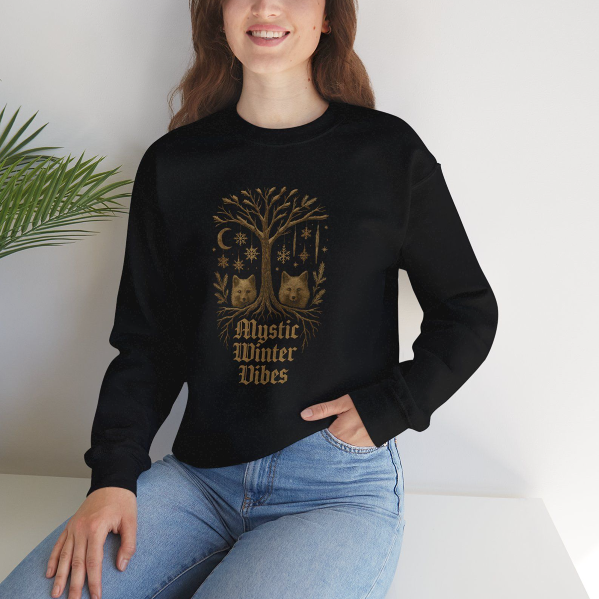 Person wearing a black sweatshirt with a tree design and text, sitting against a white background.