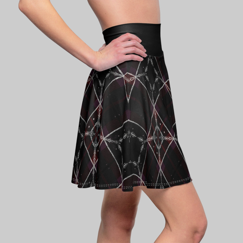Black skirt with spider web pattern worn by a person on a white background