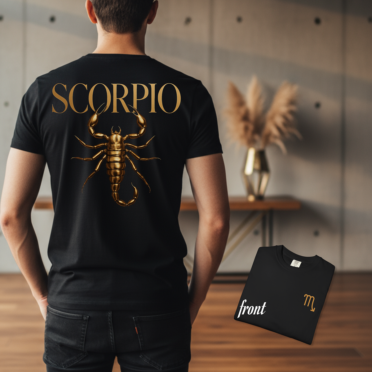 Person wearing a black t-shirt with a gold Scorpio design, standing in a room with a vase and decor.